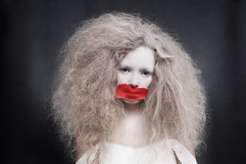 Young woman with red tape on mouth 