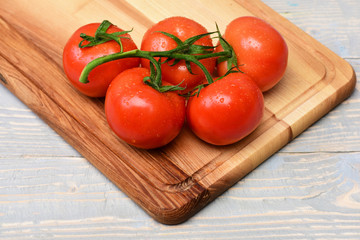 Tomatoes, cherry on vine on cutting board, grey vintage background