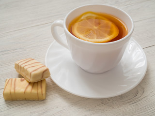 A cup of tea with lemon on a wooden table
