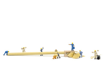 Miniature worker team sharpening a pencil on white background