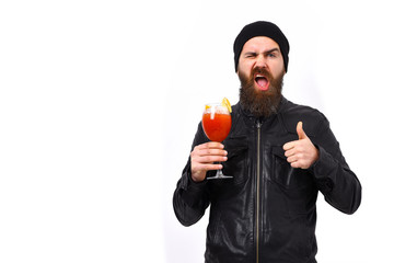 Fototapeta premium Brutal caucasian hipster holding alcoholic beverage or fresh cocktail