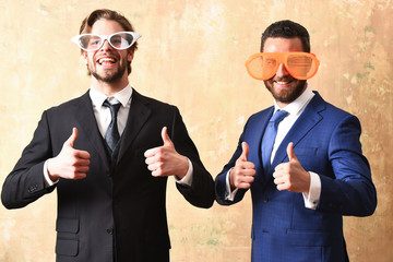 businessmen in suits and funny glasses celebrating deal conclusion
