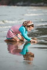 Girl building sandcastle on the beach 