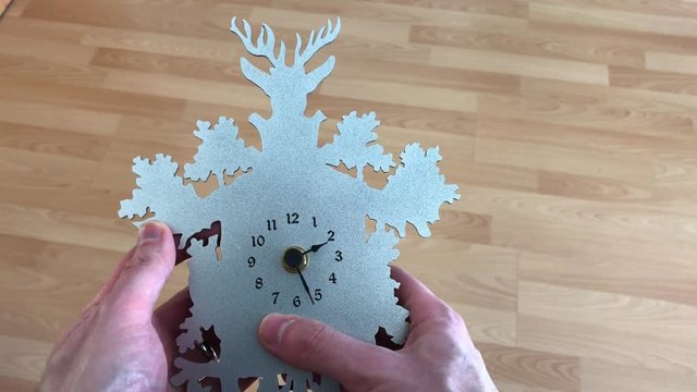 Person stellt Uhr zur Zeitumstellung von Winter auf die Sommerzeit mit der Hand und dem Finger eine Stunde vor