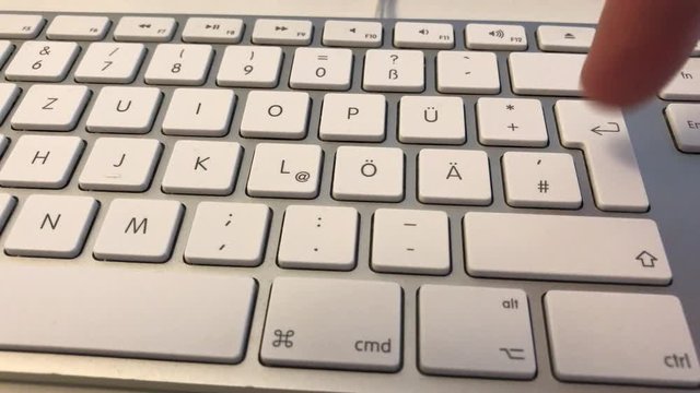 Eine Person dr&uuml;ckt mit dem Finger die Enter-Taste auf der Tastatur eines Computers im B&uuml;ro