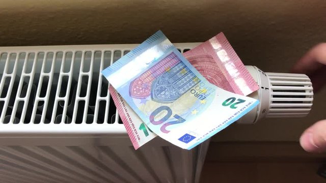 Steigende Heizkosten symbolisiert durch Geldscheine auf Heizung