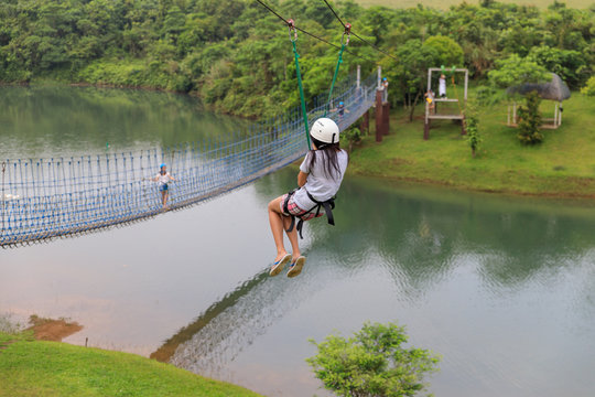 Woman sliding on a zip line adventure at Mountain lake resort in Laguna, Philippines