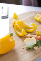 Cut vegetables on a wooden board. Red and yellow peppers, Broccoli.