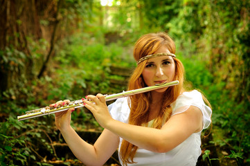Beautiful girl playing on a flute © Mihai