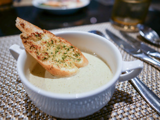 Close-up mushroom cream soup with a piece of garlic bread.