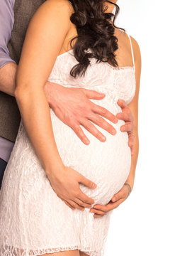 Couple embracing belly of pregnant woman