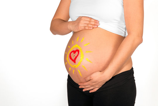 Sun and heart painted on belly of pregnant woman
