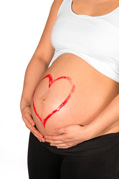 Red heart painted on belly of pregnant woman