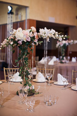 Decorative pink tree with crystal chains stands in the middle of dinner table