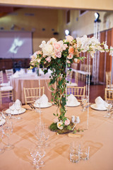 Decorative pink tree with crystal chains stands in the middle of dinner table