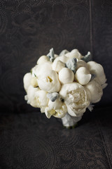 White wedding bouquet stands on the black couch