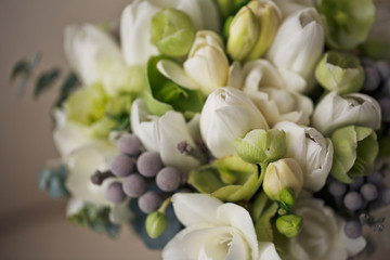 Close-up of little wedding bouquet made of white tulips and decorative grey branches