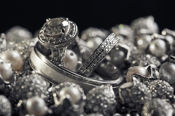 Wedding rings with white precious stones lie on the silver balls
