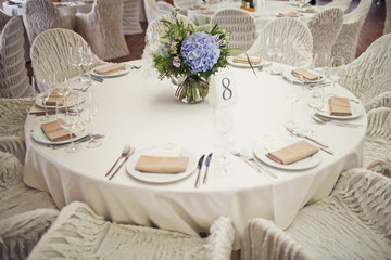 White round table number 8 decorated with blue hydrangeas