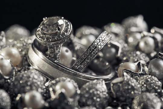 Wedding rings with white precious stones lie on the silver balls