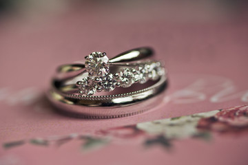 Golden wedding rings lie on pink paper