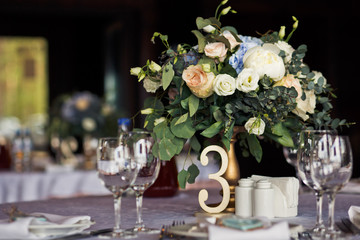 Obraz na płótnie Canvas Little rose bouquet stands on the golden vase on table number 3