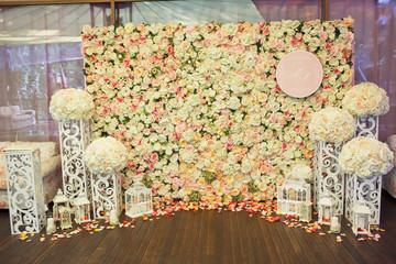 Stand covered with white and pink flowers and steel pillars before it