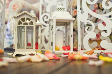 Colorful petals lie between lanterns on the wooden floor