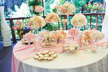 Dinner table with pink sweets decorated with beautiful flowers