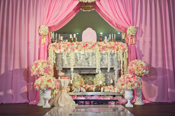 White fireplace rich decorated with roses and hydrangeas