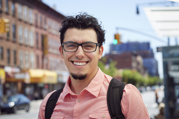 Hispanic man wearing backpack in city