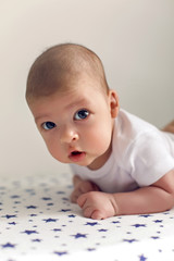 newborn lies on the stomach on a diaper with the stars