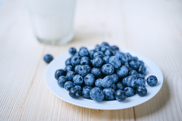 Rustic healthy breakfast with blueberry and yogurt in a glass on a wooden table. Glass of homemade yogurt with ripe berries. Healthy breakfast with vital vitamins.