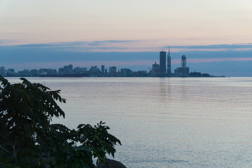 Naklejka premium Batumi At Sunset. View From Sea Beach To Cityscape With Modern Urban Architecture Skyscraper. Georgia.