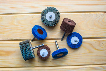 Flap Wheel. A pile of color abrasive Flap Wheel industrial on wood background texture. Great for grinding, metal finishing, sanding steel or inox. sandpaper wheel tool - professional equipment