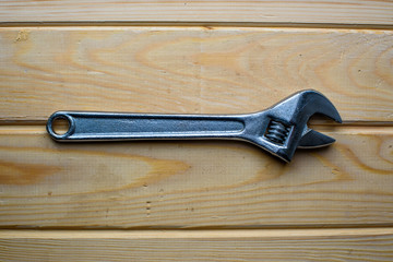 Adjustable wrench on wood background