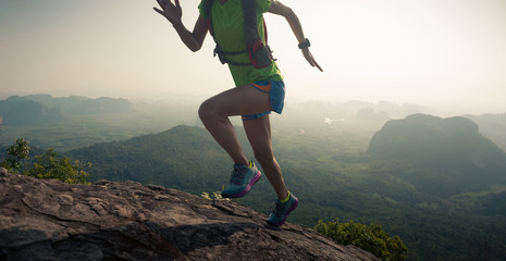 young woman trial runner running up on mountain top