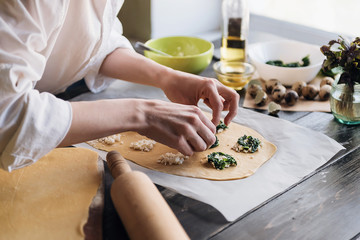 Obraz na płótnie Canvas Step by step the chef prepares ravioli with ricotta cheese, yolks quail eggs and spinach with spices. The chef prepares the filling on the dough