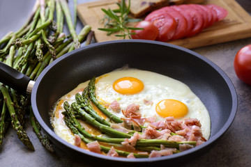 Green asparagus with eggs on an frying pan