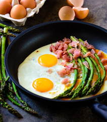 Green asparagus with eggs on an frying pan