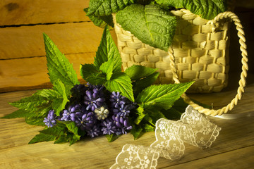 Bouquet of flowers and a wicker basket on a wooden background 2