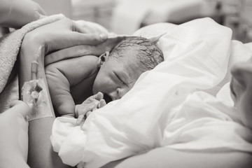 Newborn baby boy after birth is on her mother's arms