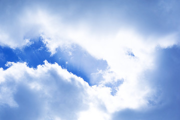 Clouds blue sky with sun lights coming behind bright vibrant spring autumn nature background photo in blue white gray colors