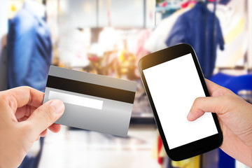 Hand holding smart phone with credit card on blur store, online shopping background, business, E-commerce