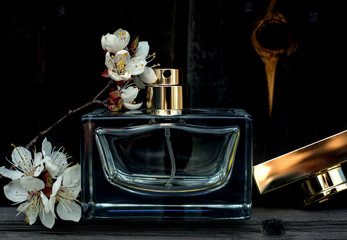 Female perfume with flowers in wooden background