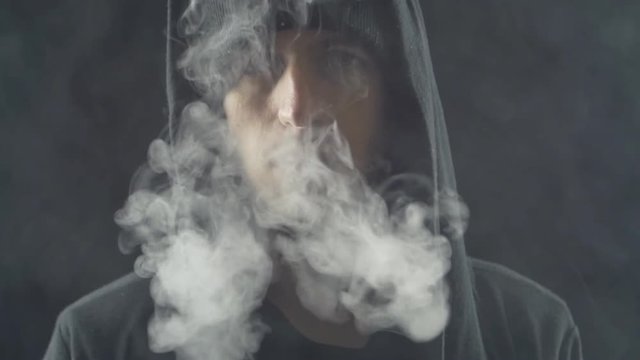 Close up Man vaper makes smoke with electronic cigarette in slow motion