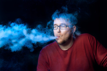 The man releases a jet of vapor. Dark background