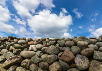 Old Stone wall with blue sky and clouds above