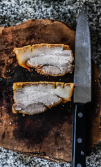 Crispy pork on wooden block and knife