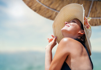 Woman in big straw hat enjoyed with summer sun
